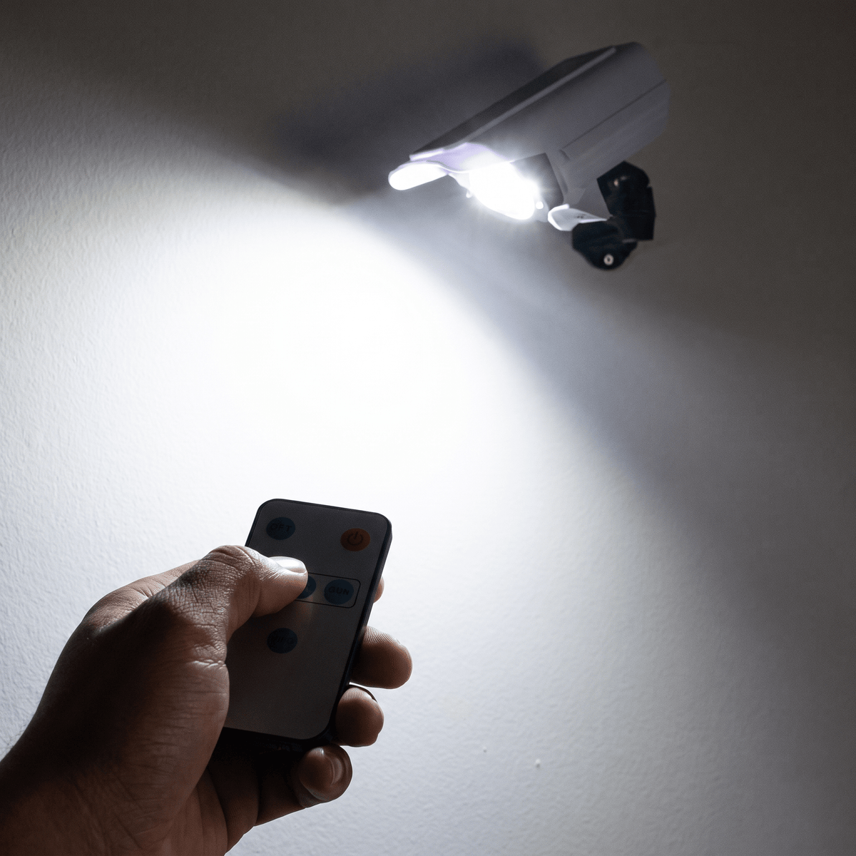 Nomedo Solar Camera-Lamp, schaalbeeld met hand en afstandsbediening
